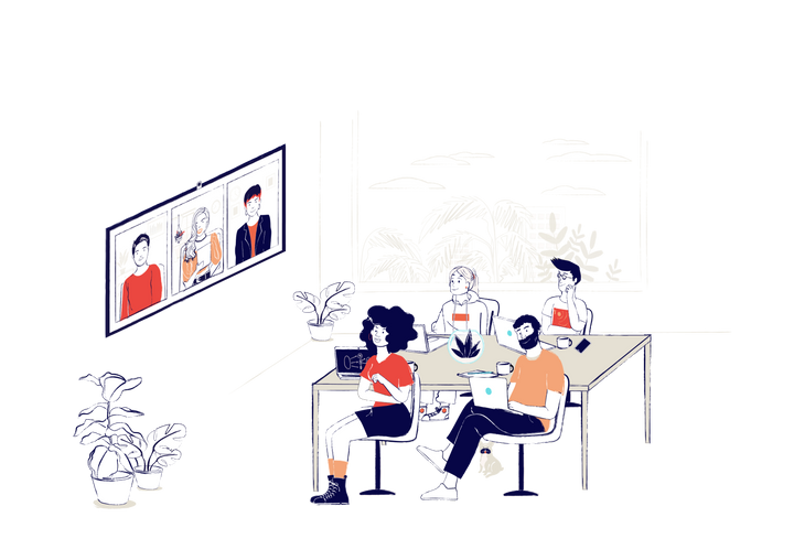 A hybrid meeting: four employees sit around a desk with three more employees on a video chat on the wall